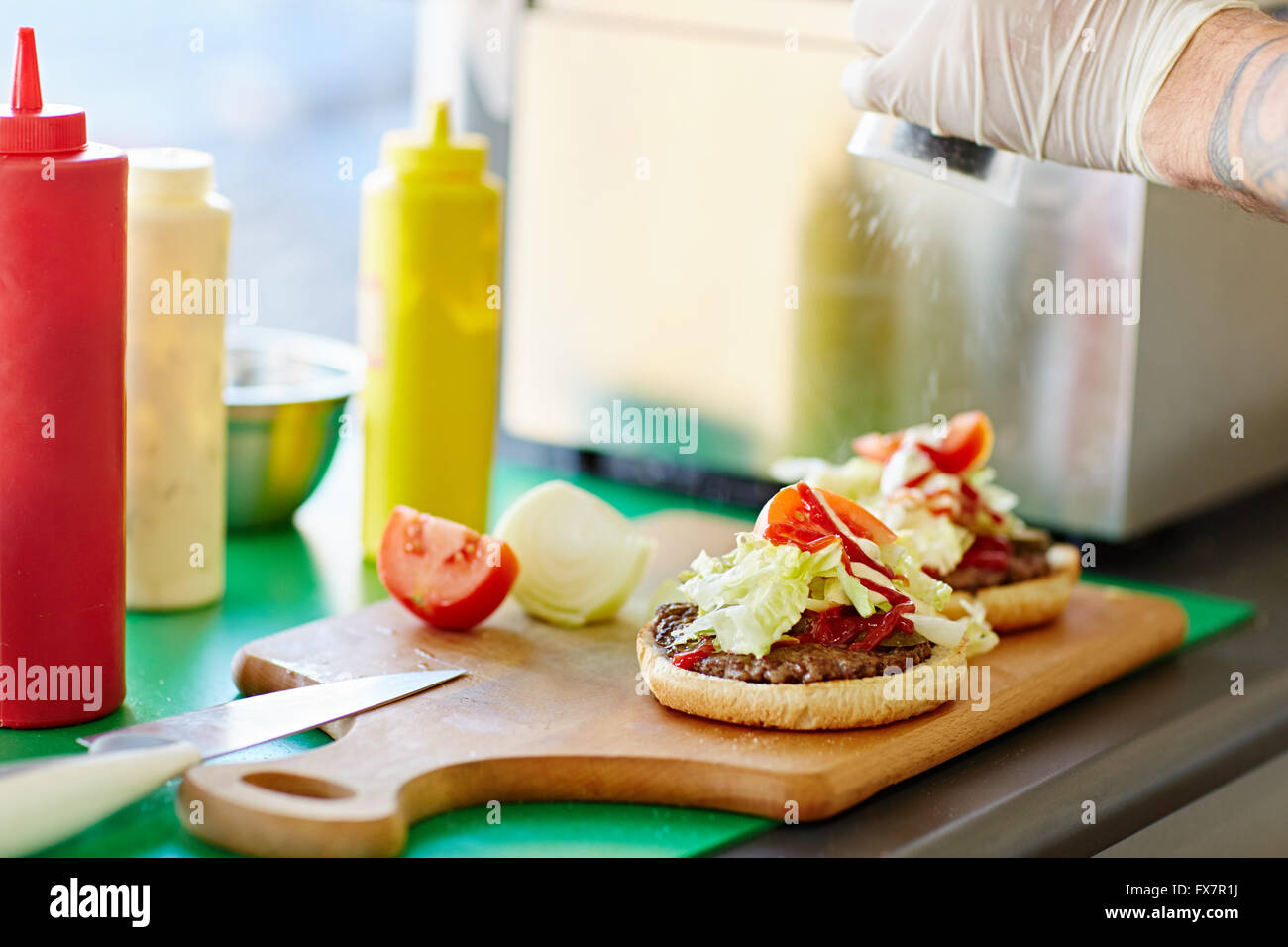 Freshly made open takeaway burger on a wooden board Stock Photo