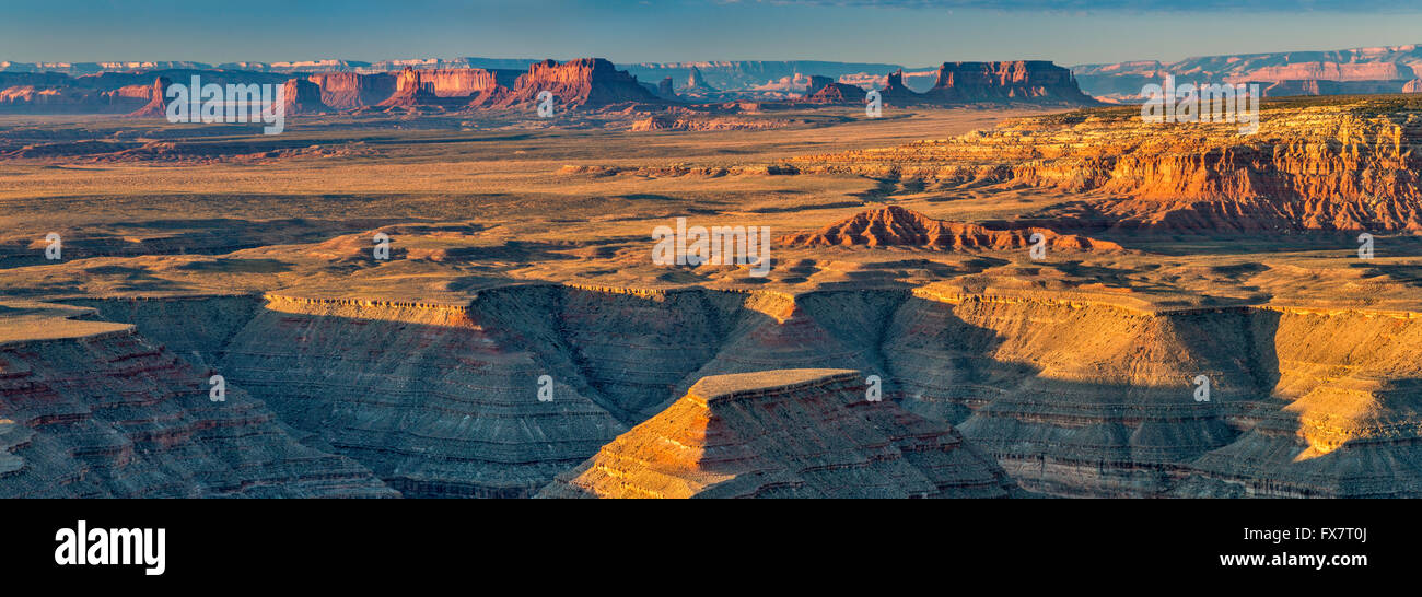 Goosenecks of San Juan River, Monument Valley buttes in distance, at sunrise, view from Muley Point on Cedar Mesa, Utah, USA Stock Photo