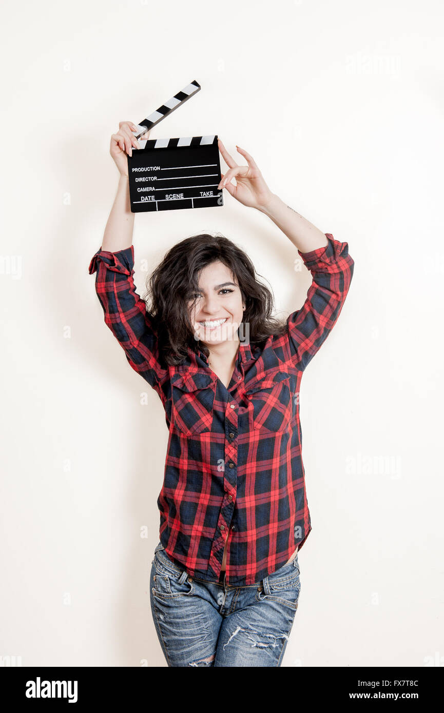 Smiling brunette woman actress with movie clapper board up on white background Stock Photo