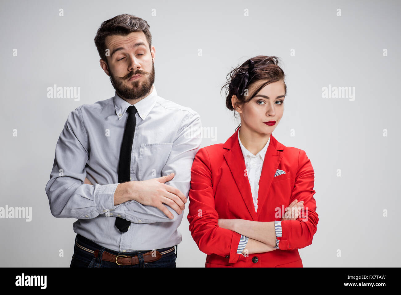 The funny sad business man and woman conflicting on a gray background. Business concept  of relationship of colleagues Stock Photo