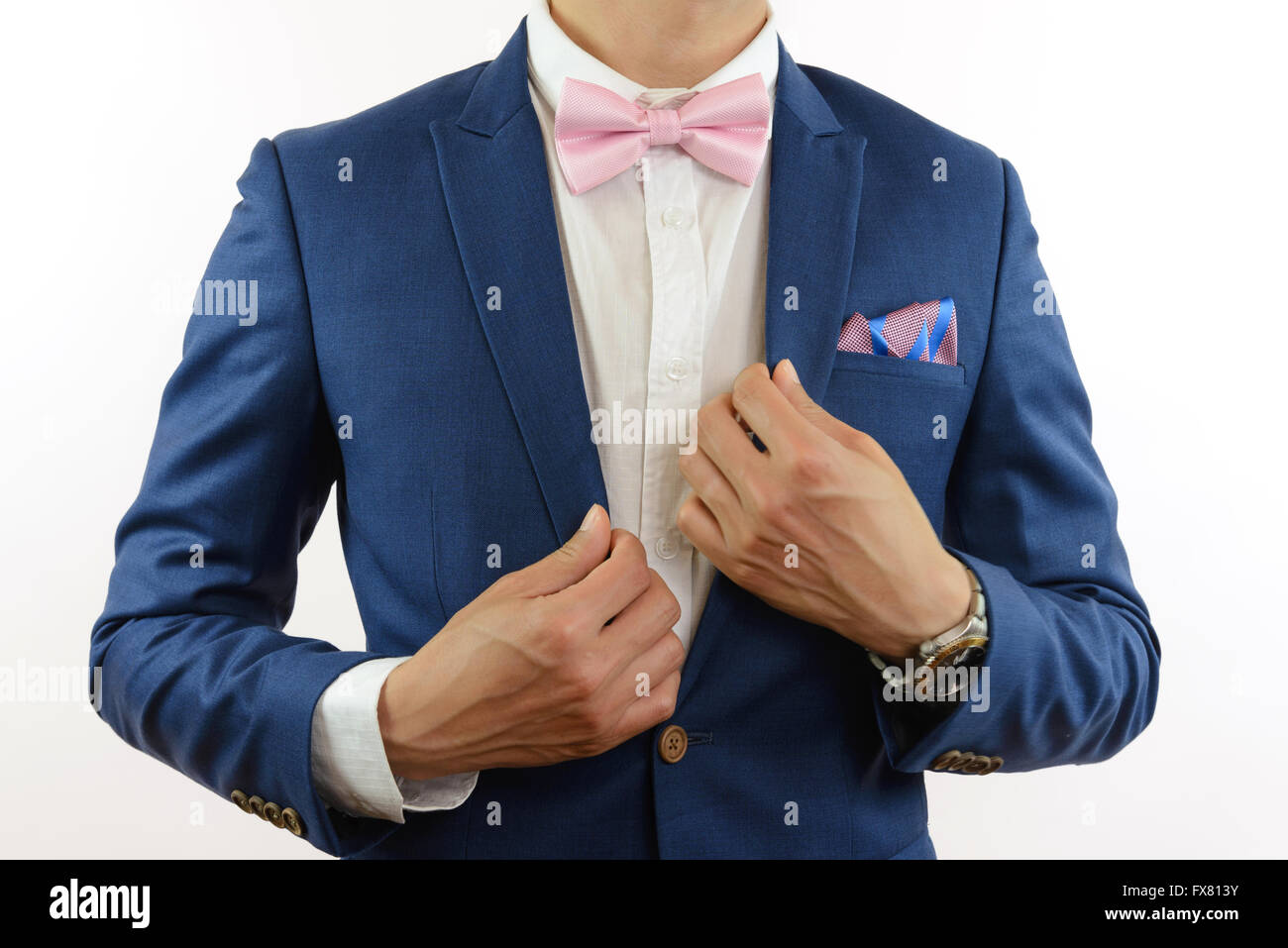 Man in blue suit with pink bow tie, flower brooch, and pink blue strip