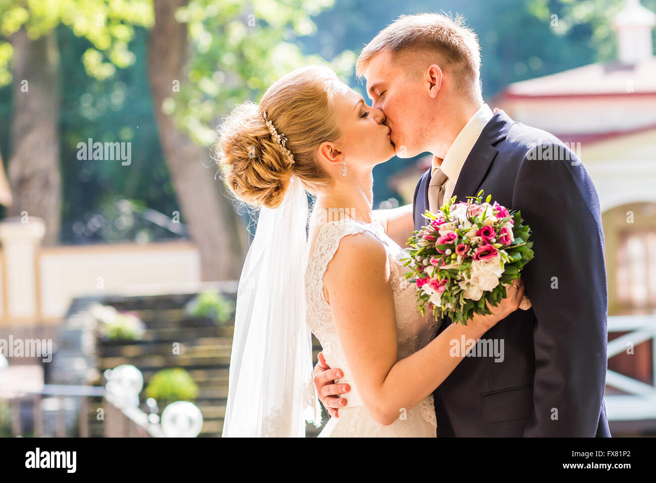 Kiss the bride and groom Stock Photo - Alamy