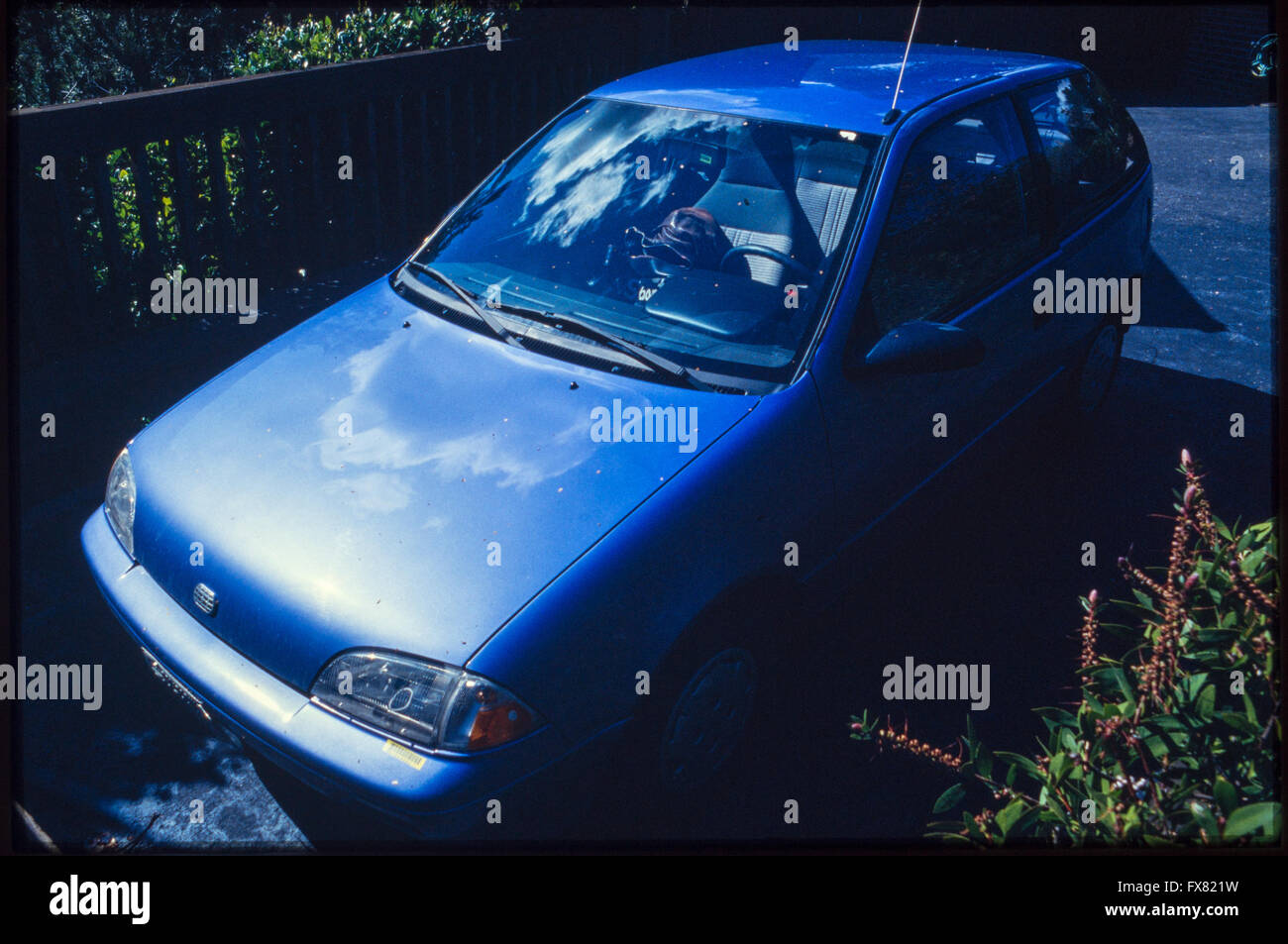 Archive image of a metallic blue 1990 model Geo Metro 3-door subcompact hatchback car on a suburban drive in San Rafael, California, USA, 1990 Stock Photo
