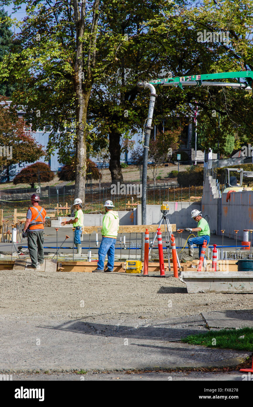 Construction workers pour concrete at the site of the expanded Oregon