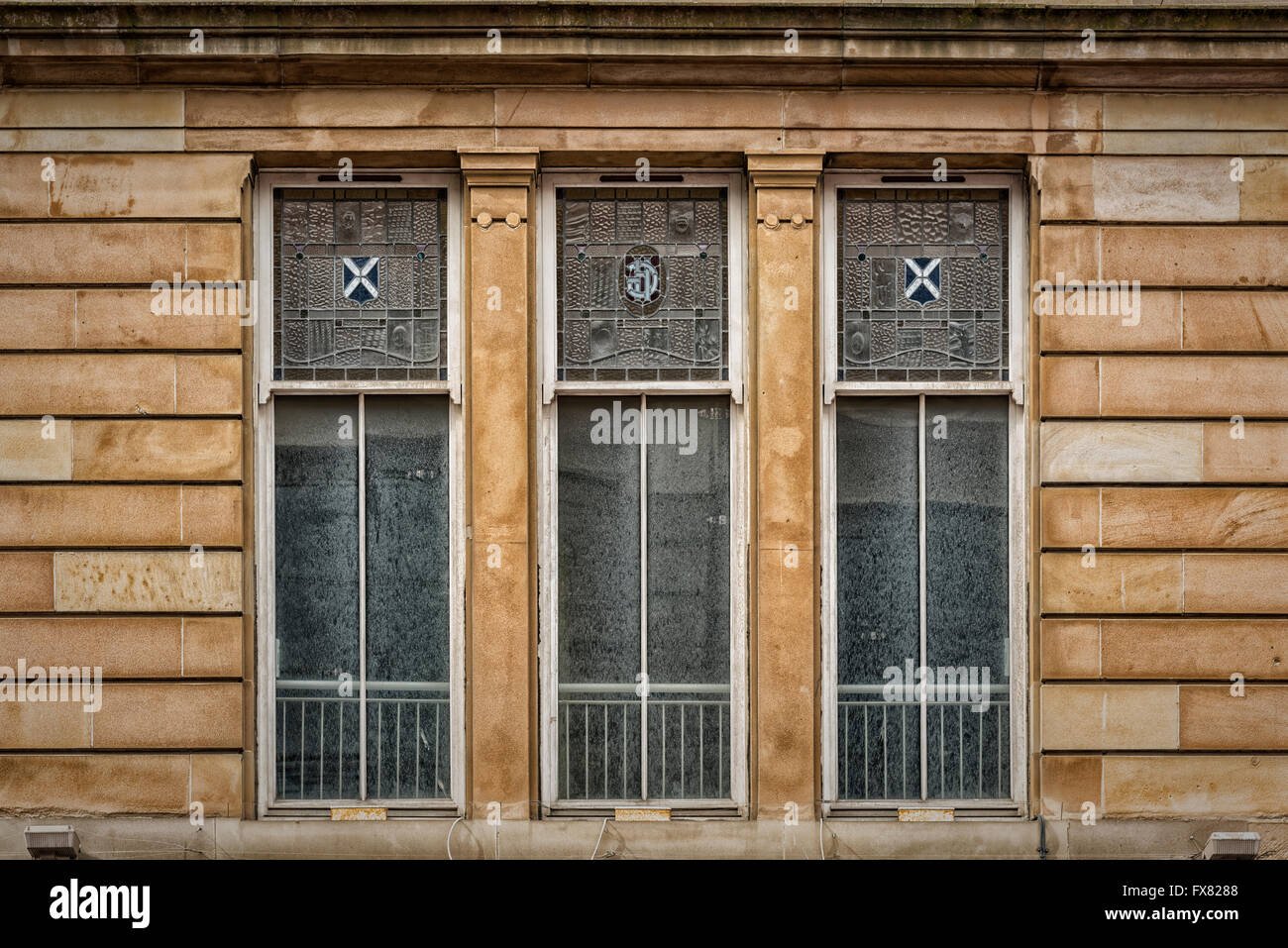 Three windows on an old tenement building in the Scottish city of Glasgow. Stock Photo