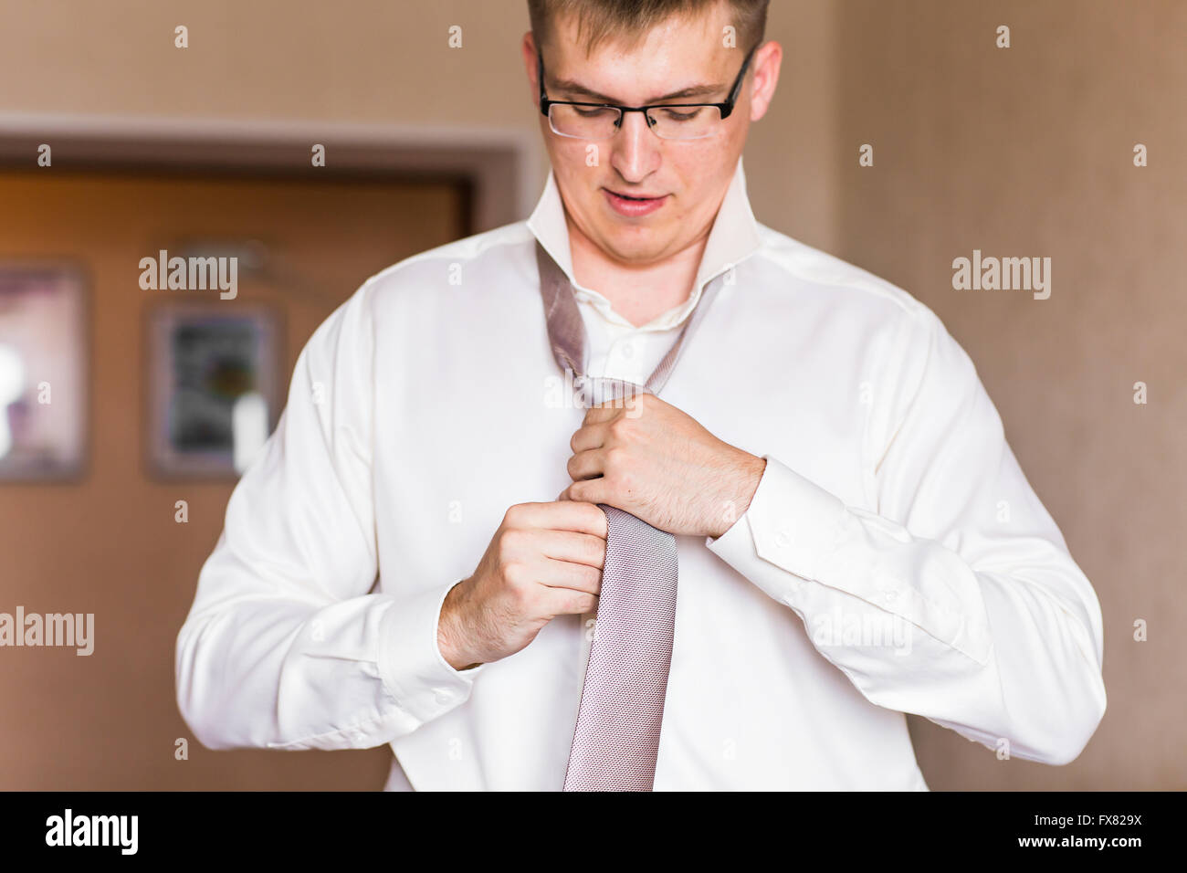 Man in a suit fixing his tie Stock Photo - Alamy