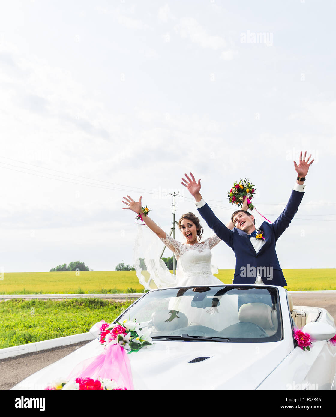 The groom and the bride in a white convertible car Stock Photo - Alamy