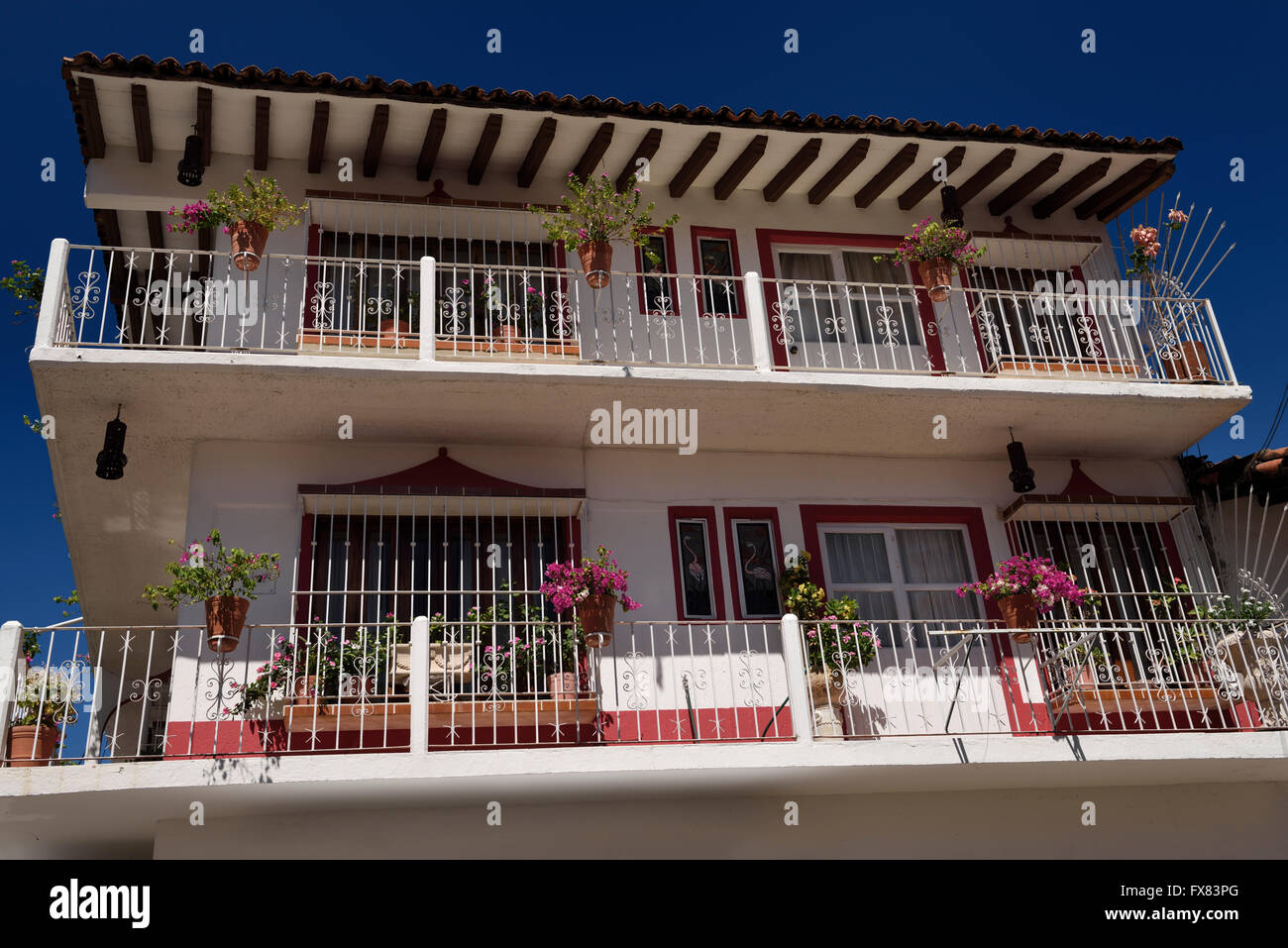 Three story hacienda in downtown Puerto Vallarta with flower pots on balcony Stock Photo