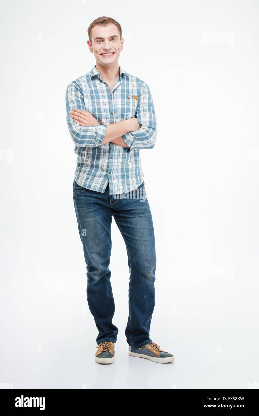 Full length portrait of a smiling casual man standing with arms folded ...