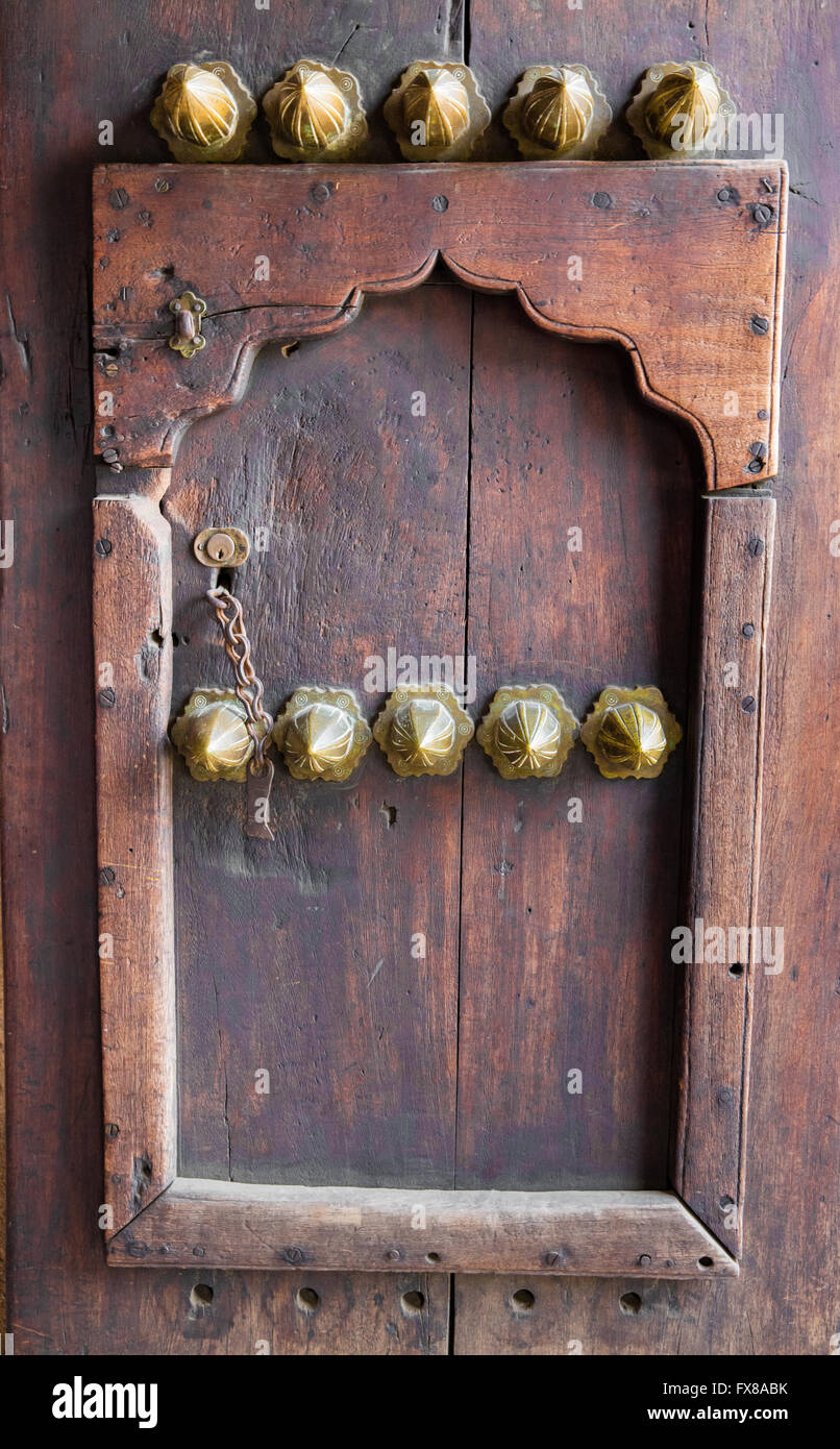 Door in a door at the entrance of the Old Arab Fort in Zanzibar East Africa with pointed brass pommels to deter enemy elephants Stock Photo