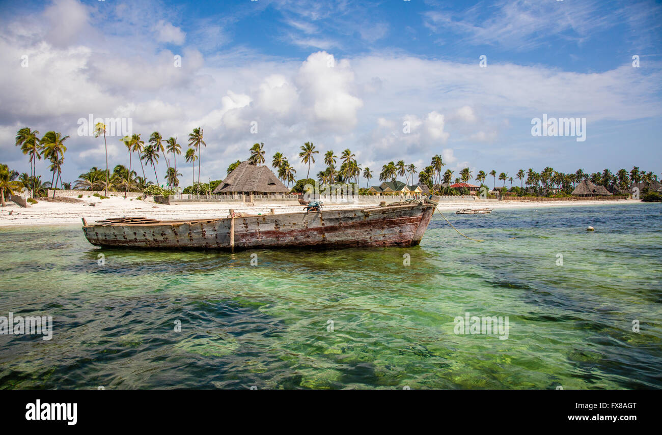 Old dhow boat and palm fringed beach on the east Zanzibar coast near Mchanga Stock Photo