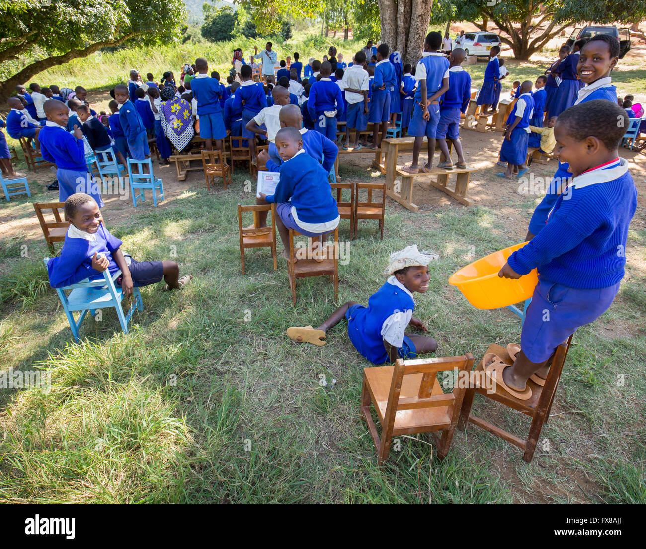 Boys at the back of a school outdoor prize giving ceremony in the Sagalla district of Kenya  laughing and having fun Stock Photo