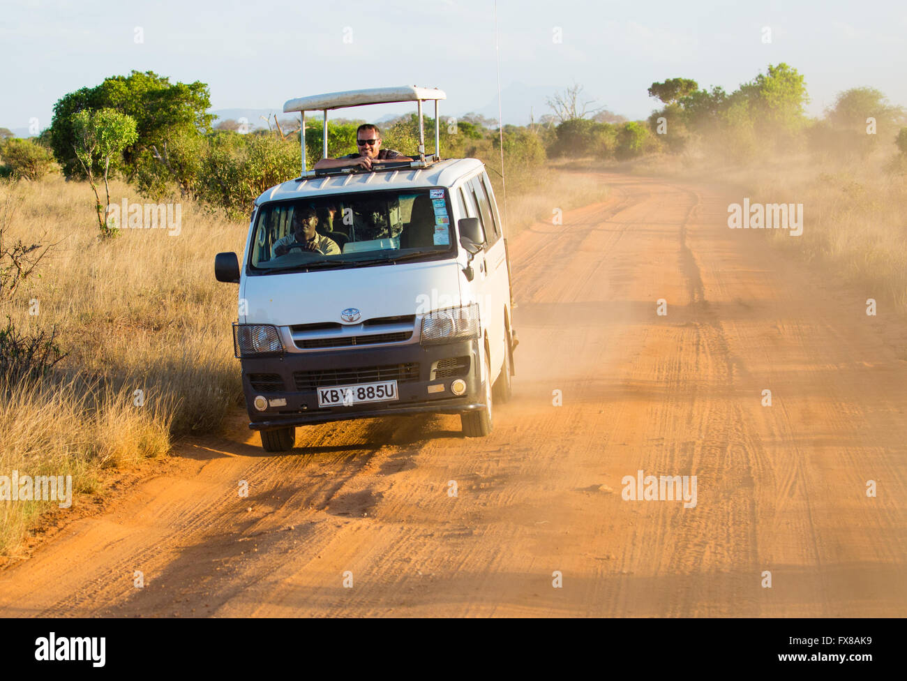 Flip top Toyota safari van driving the red dirt tracks of Tsavo National Park in Southern Kenya looking for wildlife Stock Photo