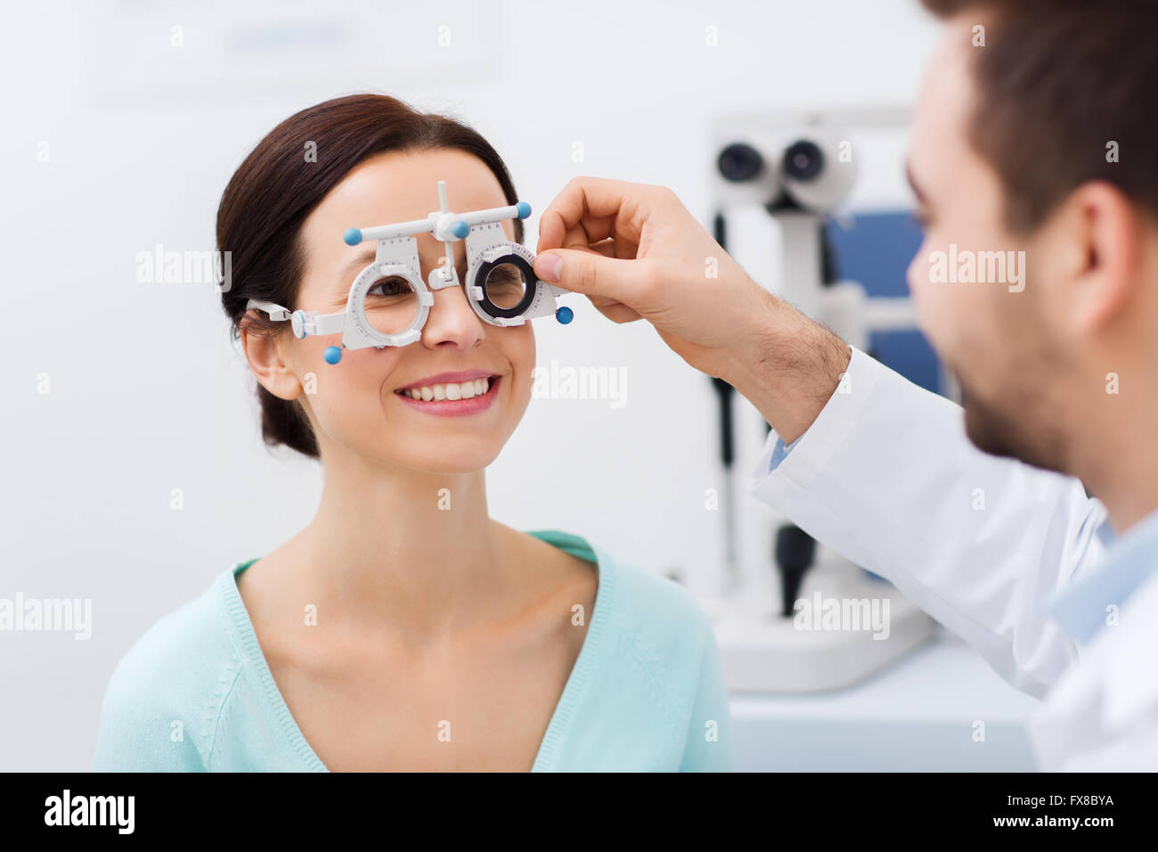 optician with trial frame and patient at clinic Stock Photo
