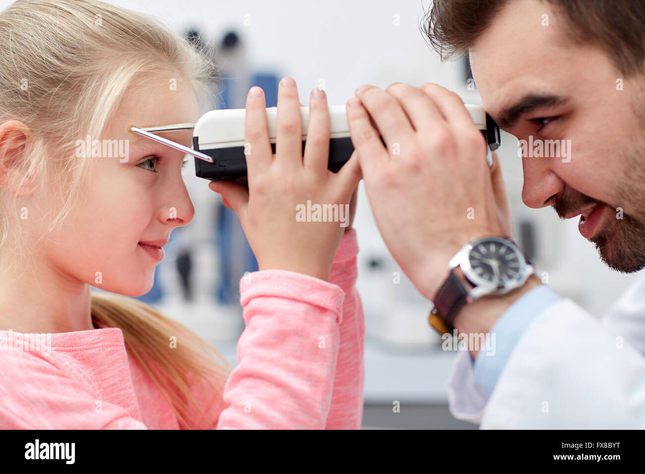 optician with pupilometer and patient at eye clinic Stock Photo