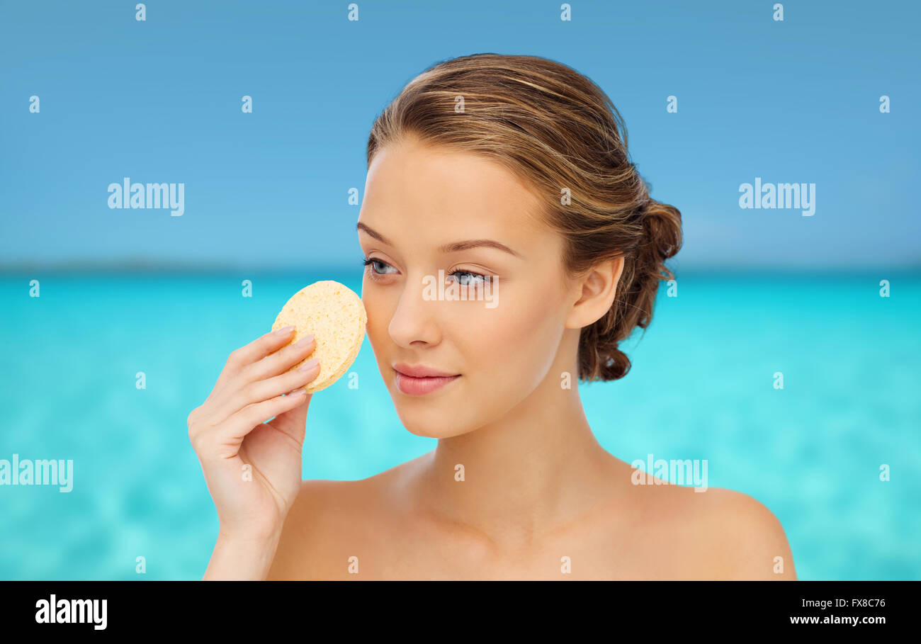 young woman cleaning face with exfoliating sponge Stock Photo