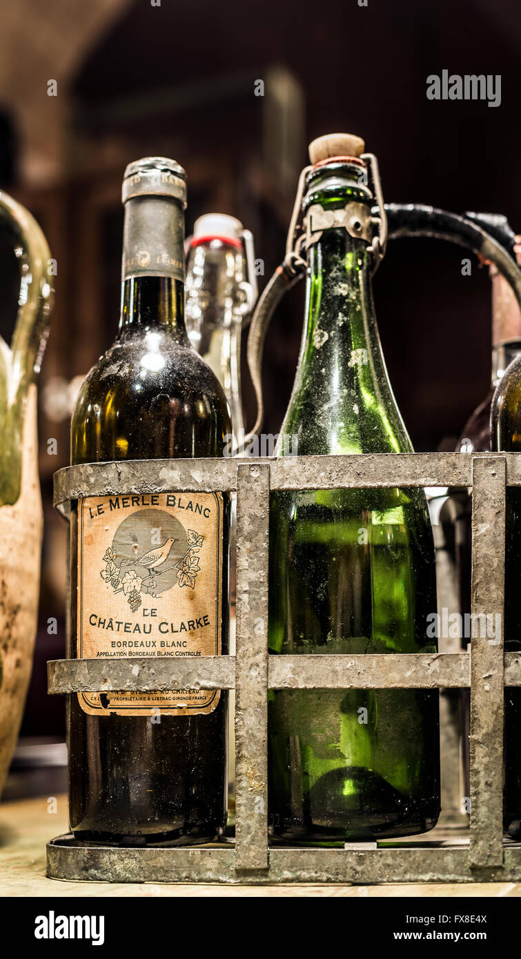 Antiques french wine bottles from Bordeaux in a vintage metal bottle carrier. Aquitaine, France. Stock Photo