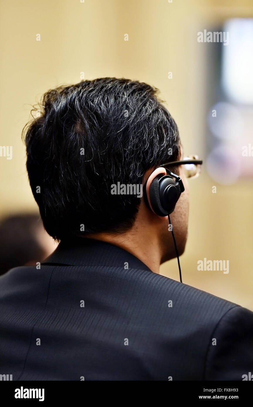 Unrecognizable woman using headphones for translation during event Stock Photo