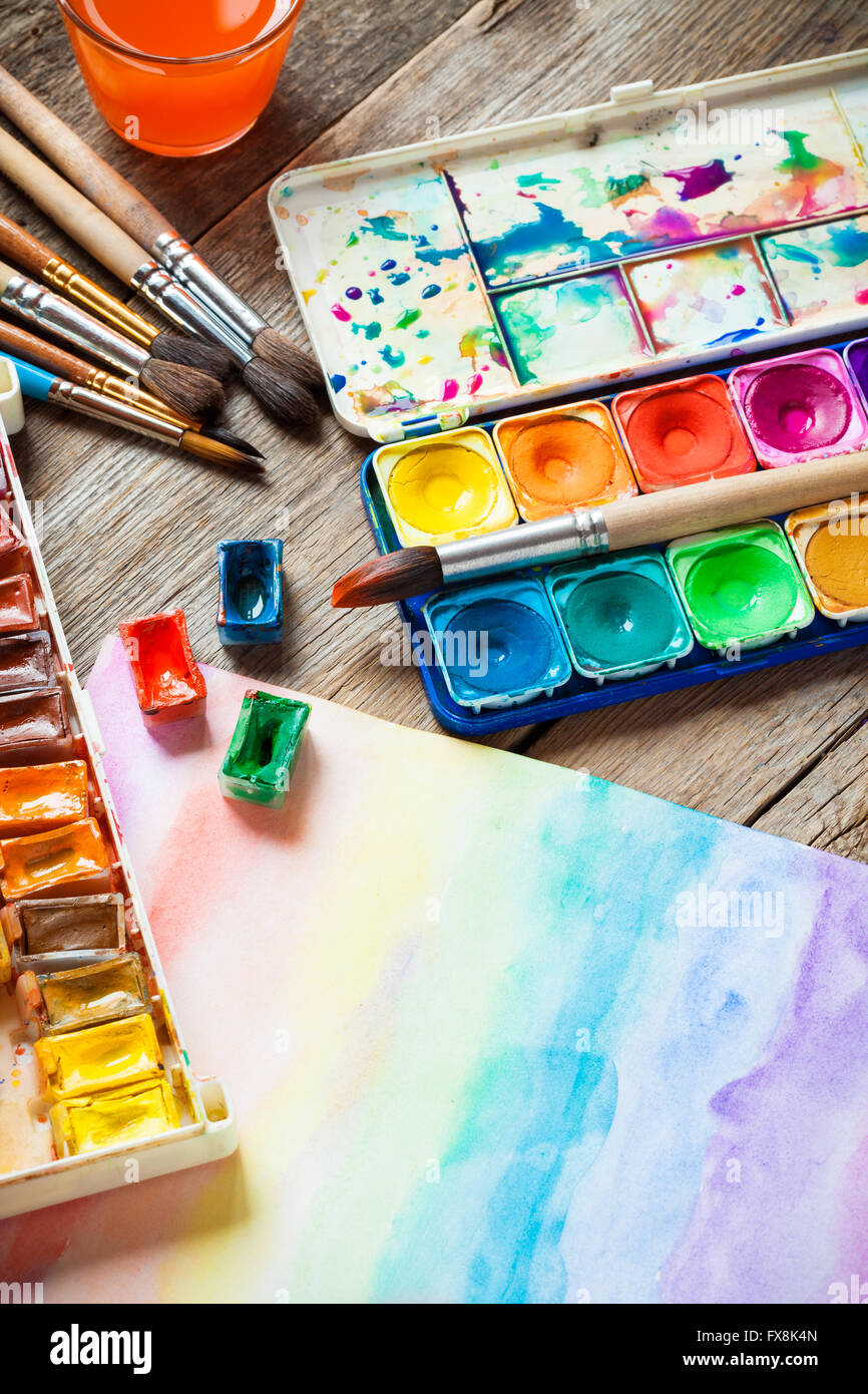 Watercolor paints, brushes for painting and paper sheet of painting on