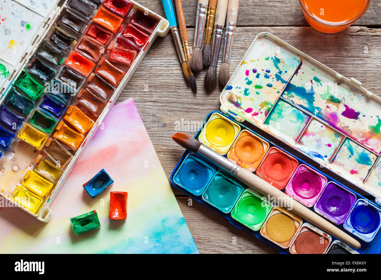 Set of watercolor paints, brushes for painting and paper sheet of