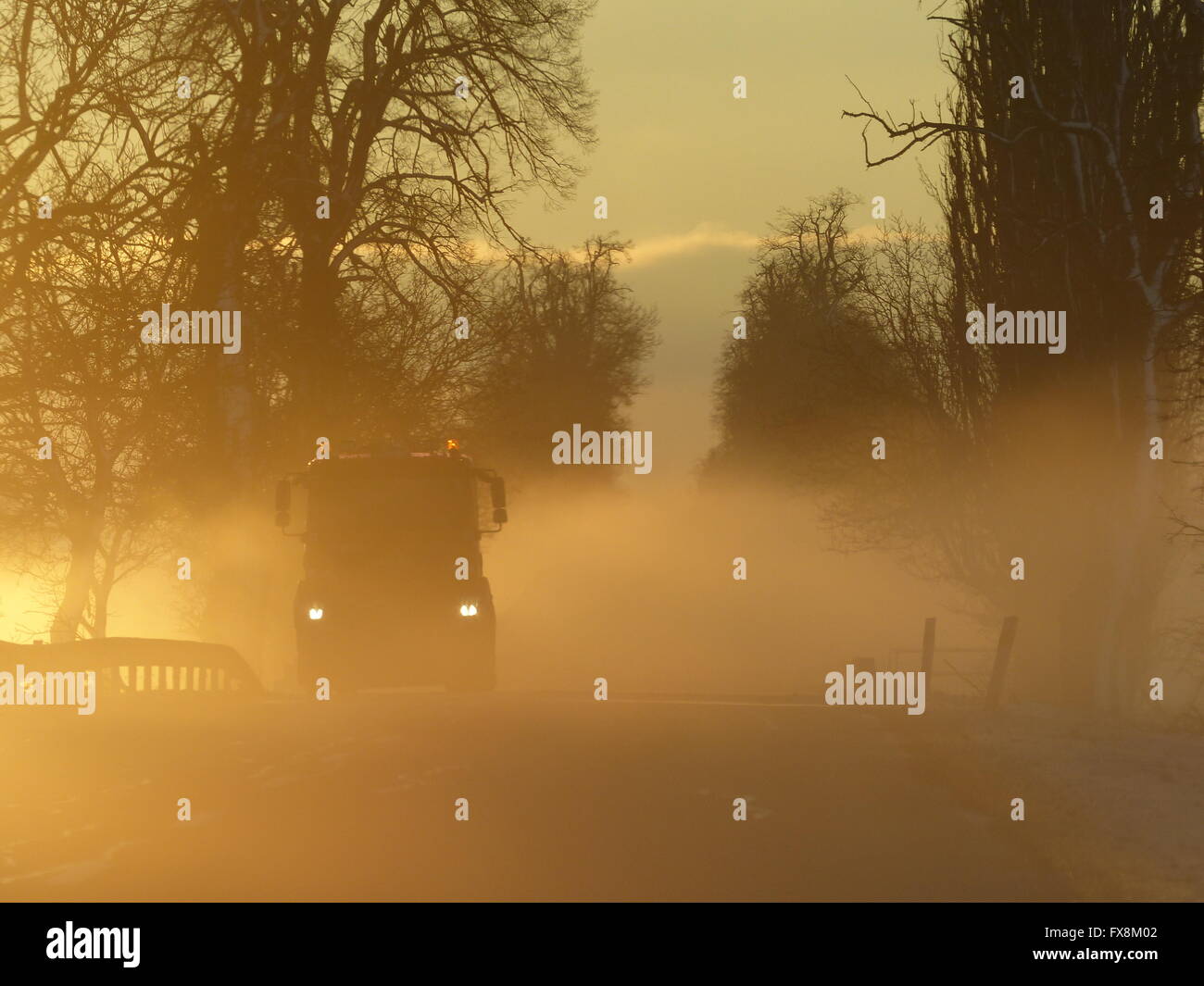 Road with sunrise and fog creating dangerous driving conditions Stock ...