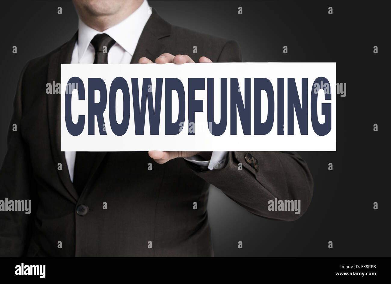 crowdfunding sign is held by businessman. Stock Photo