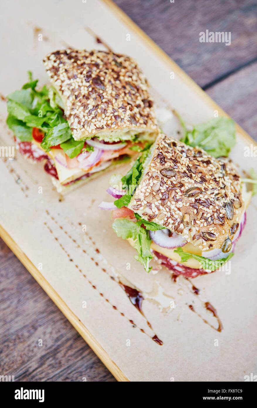 Seeded bread sandwich with fresh lettuce, salami, cheese and tom Stock Photo