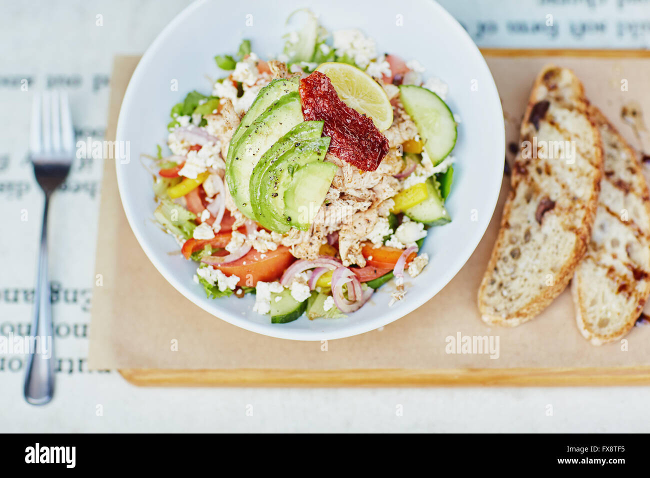 Fresh salad with avocado and tomato presented rustical Stock Photo