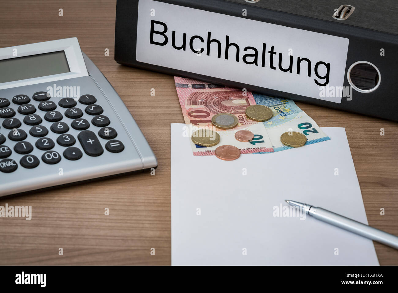 Buchhaltung (German Accounting) written on a binder on a desk with euro money calculator blank sheet and pen Stock Photo