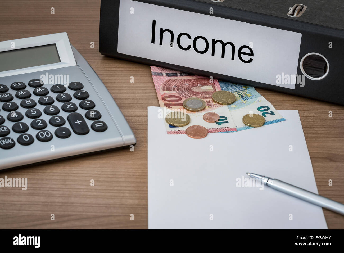Income written on a binder on a desk with euro money calculator blank sheet and pen Stock Photo