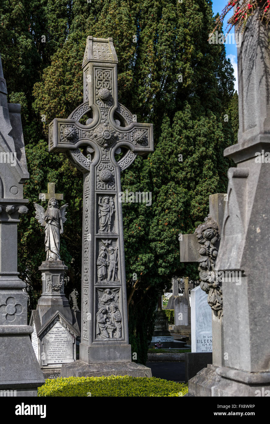 A stonework Celtic cross stands over a grave in Glasnevin cemetery in Dublin. Stock Photo