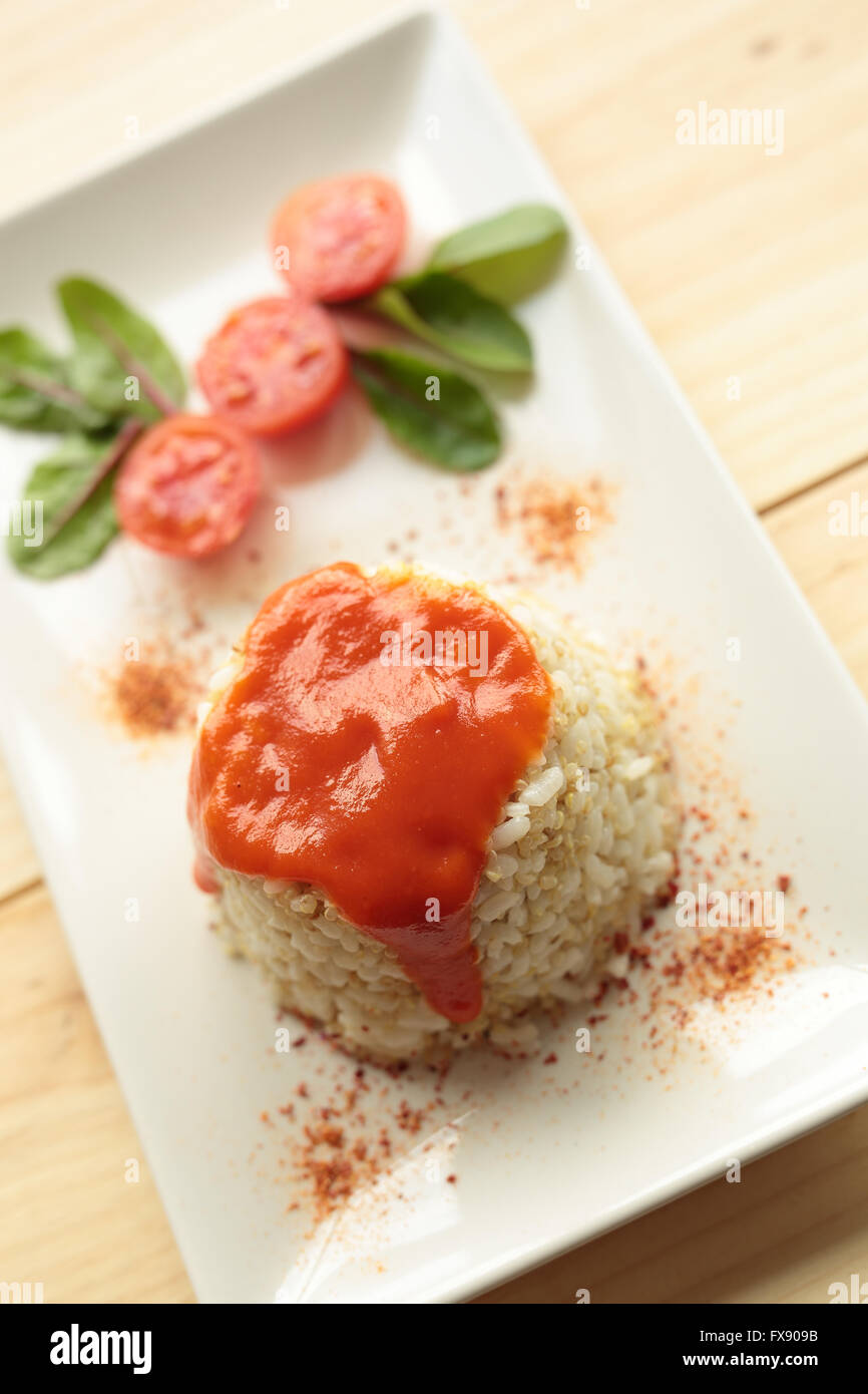 Cuban style rice decorated with cherrys tomatoes and a green leaves. Stock Photo