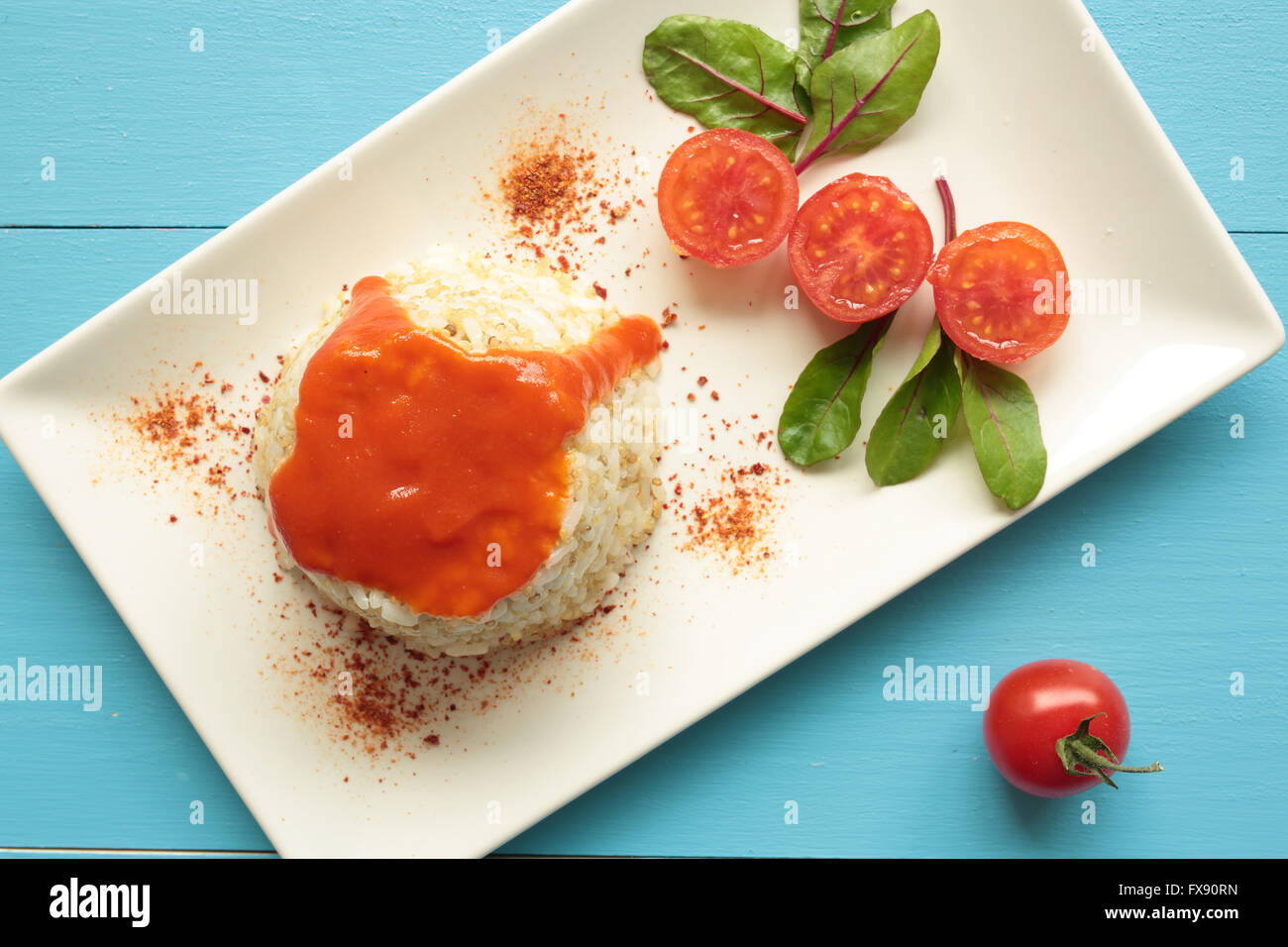 Cuban style rice decorated with cherrys tomatoes and a green leaves. Stock Photo