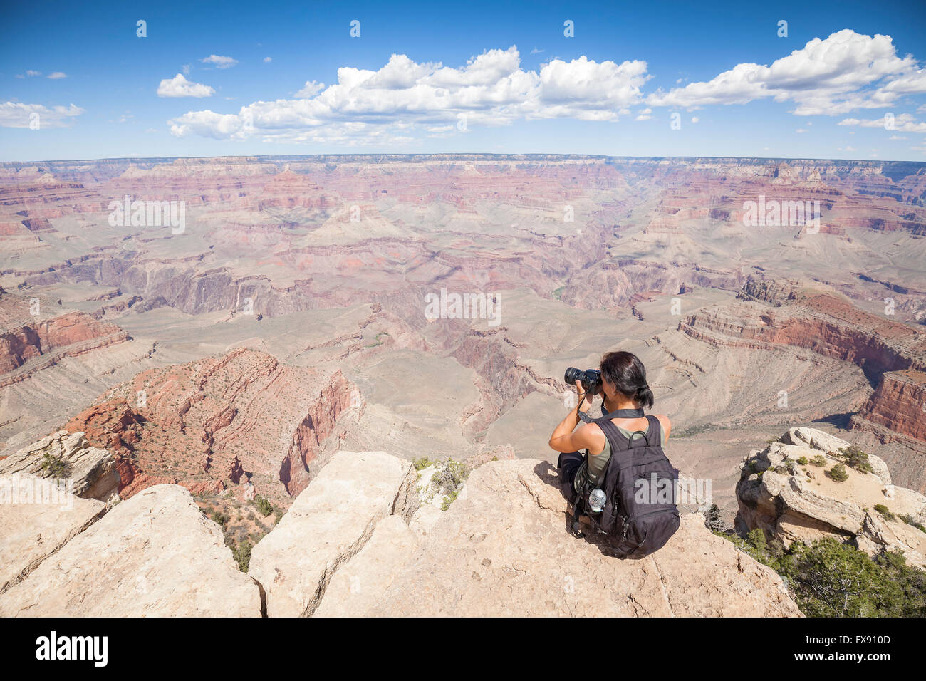 Young woman taking pictures of the Grand Canyon, hobby and adventure concept. Stock Photo