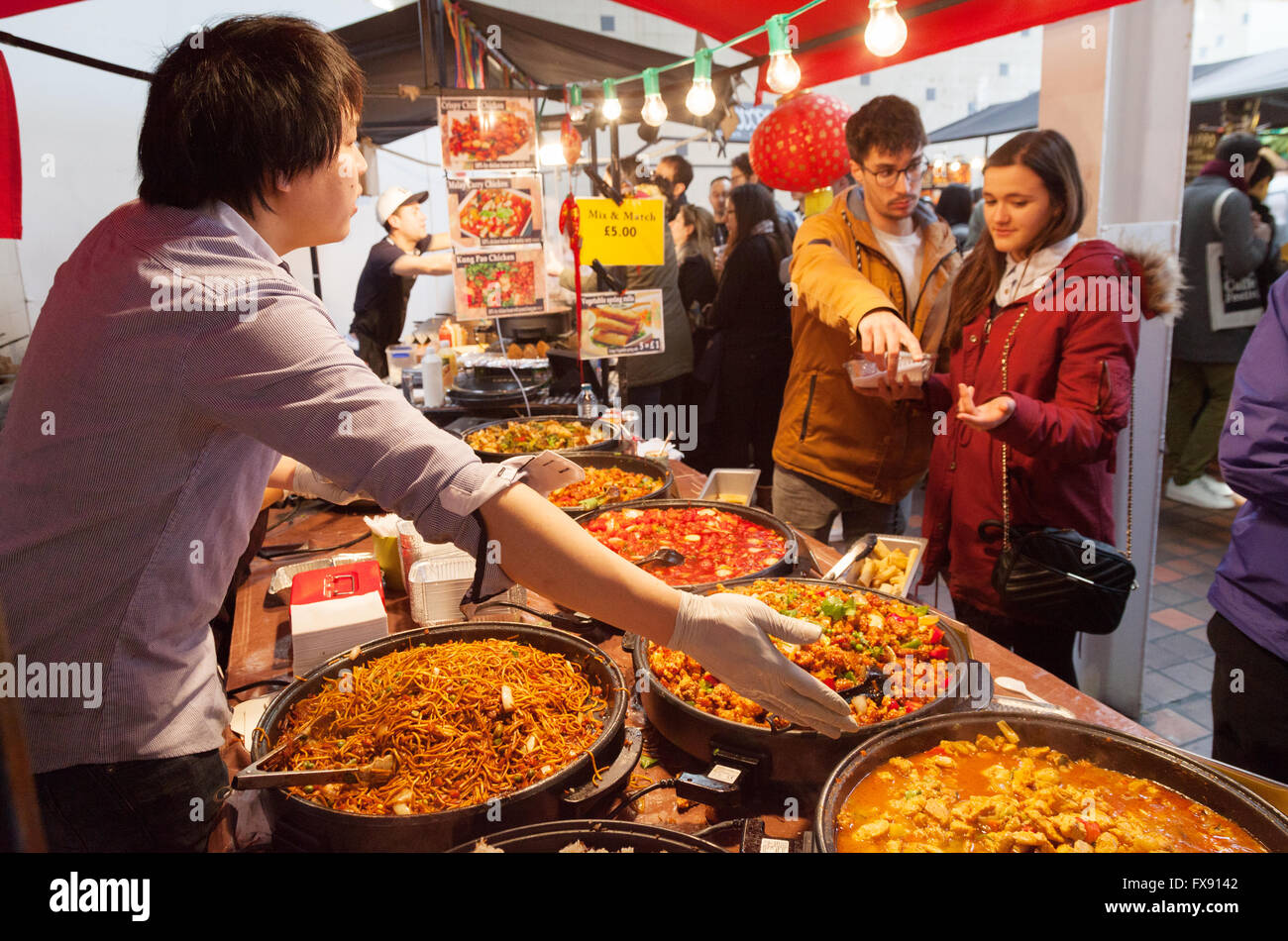 London market; People buying street food at a chinese street food stall, example of multicultural Britain,Brick Lane Spitalfields, London East End, UK Stock Photo