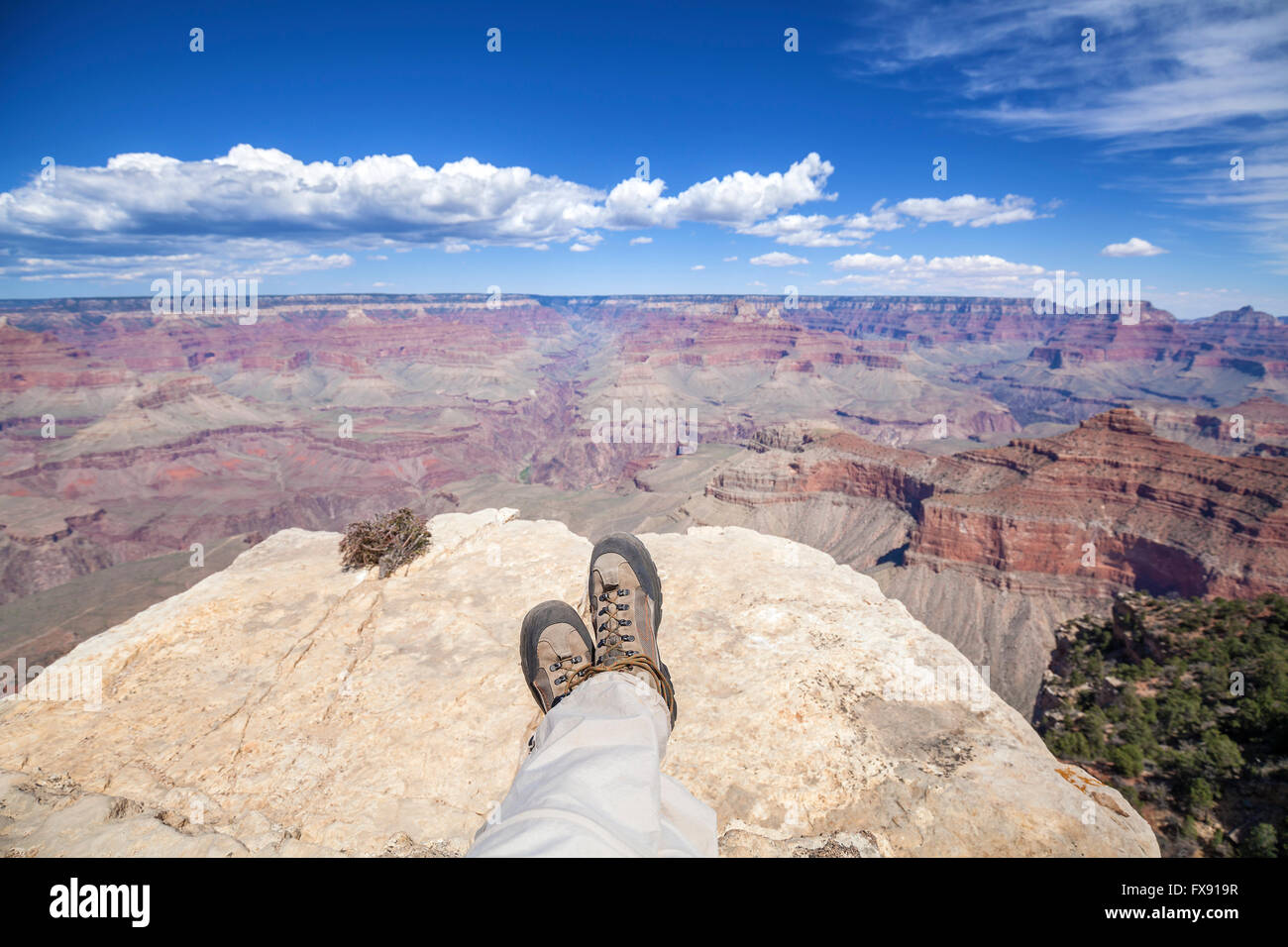 Legs with old trekking shoes by the Grand Canyon cliff, adventure concept photo. Stock Photo