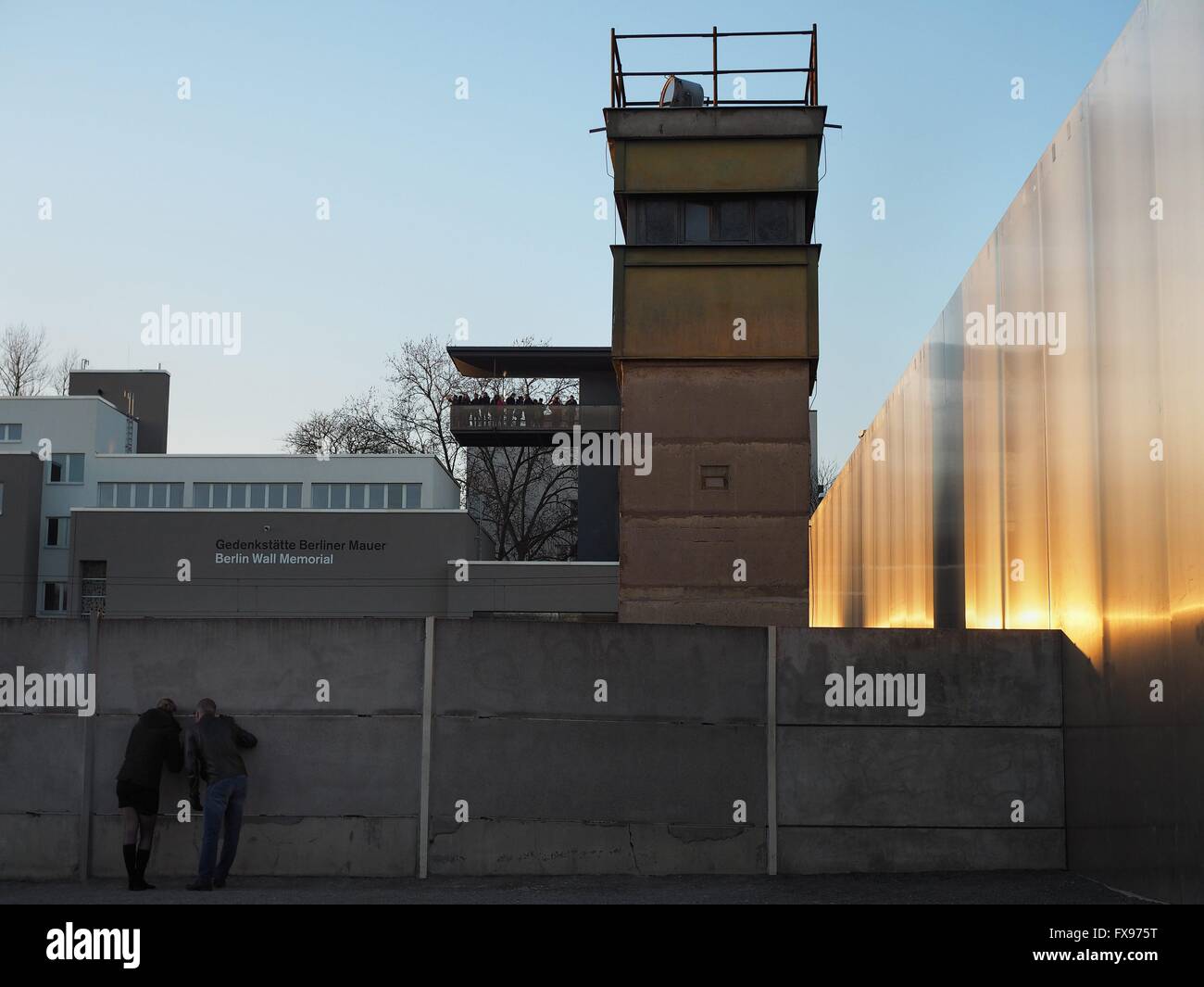 Visitors are looking trough a whole in a part of the wall at the Berlin Wall Memorial in Berlin at Bernauer Straße on December, 30, 2015. Photo: Wolfram Steinberg/dpa Stock Photo