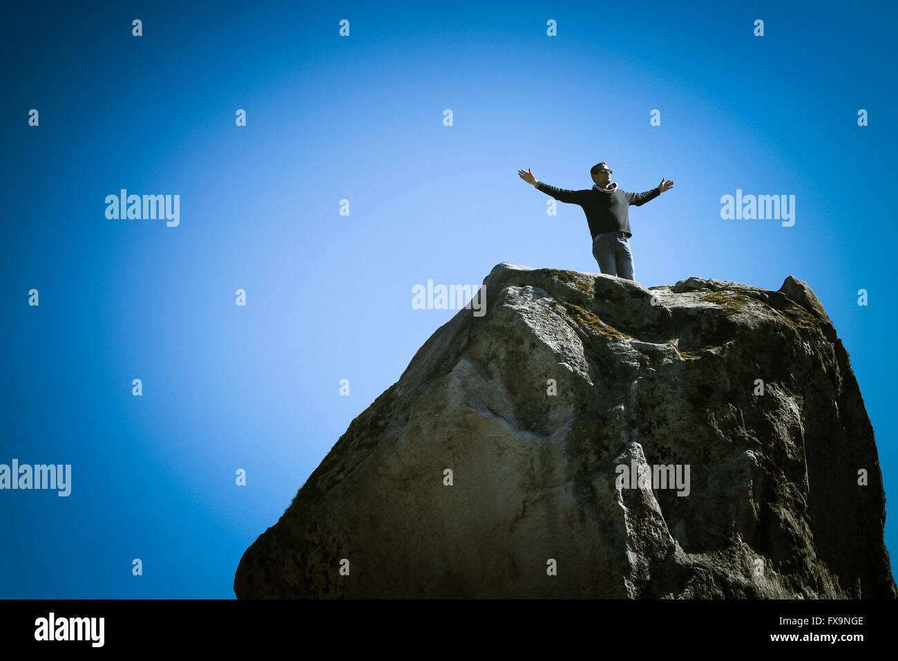 A man on top of a mountain looking at view Stock Photo - Alamy