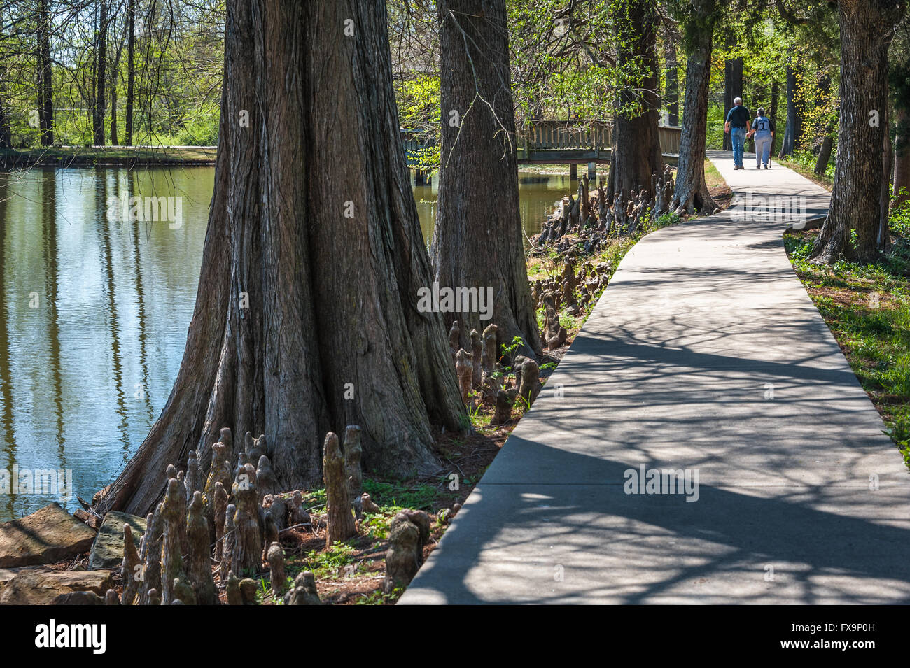 Senior couple holding hands on a leisurely stroll around the lake at Honor Heights Park in Muskogee, Oklahoma, USA. Stock Photo