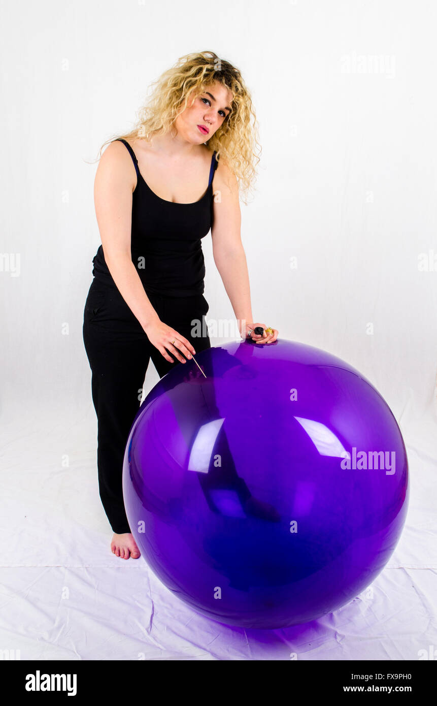 Young woman with a huge balloon and a needle Stock Photo