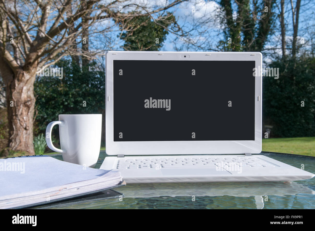 Modern laptop with a blank screen outside on a sunny day Stock Photo