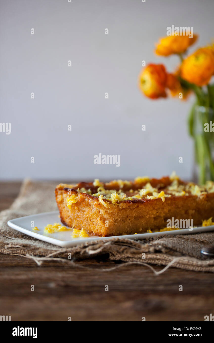 Lemon and olive oil cake on a white plate and rustic wooden table Stock Photo