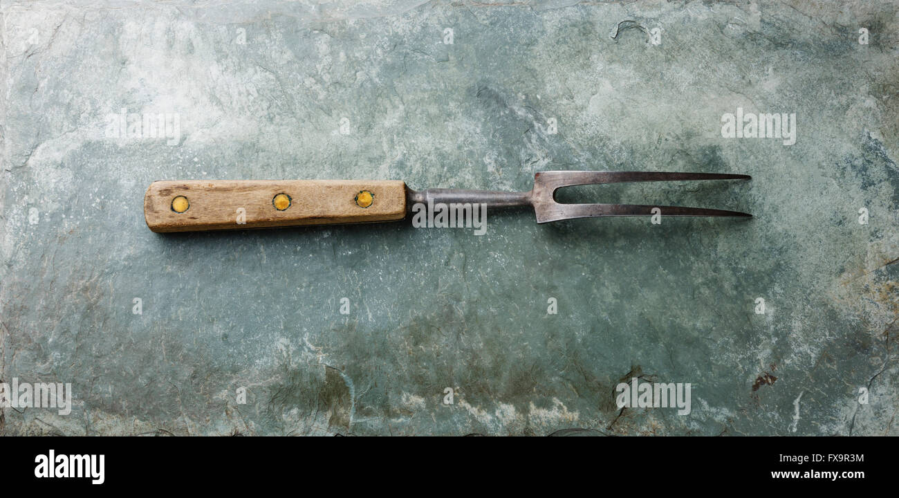 Meat fork wooden handle on gray stone slate background Stock Photo