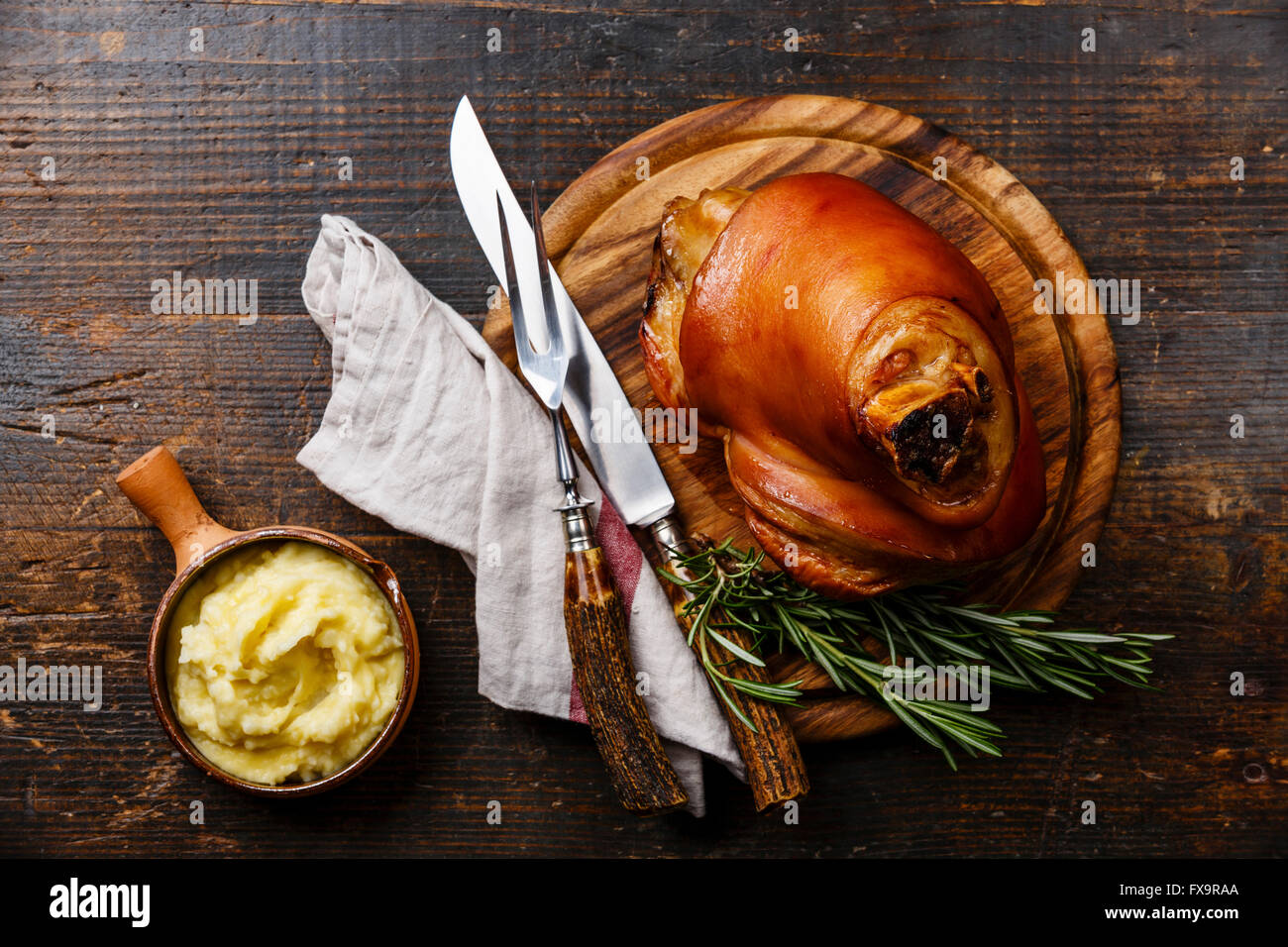 Roasted pork knuckle eisbein with mashed potatoes on wooden cutting board Stock Photo