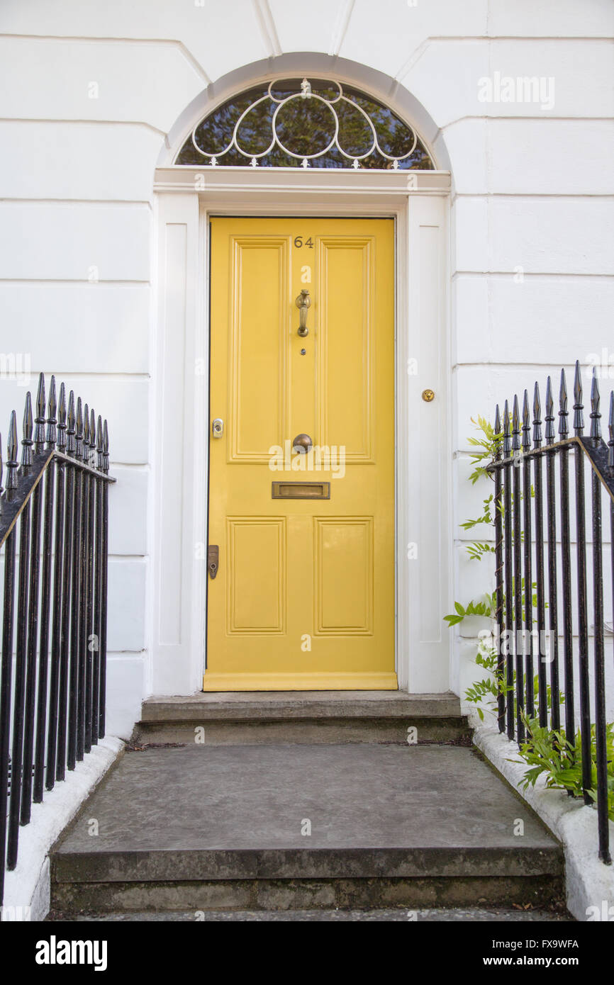 yellow Georgian era four-panel front door with fanlight on GIbson Square in Islington, north London, UK Stock Photo