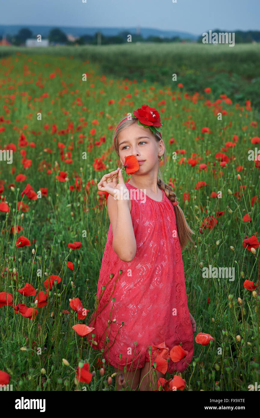 girl in red dress walks at poppy field Stock Photo - Alamy