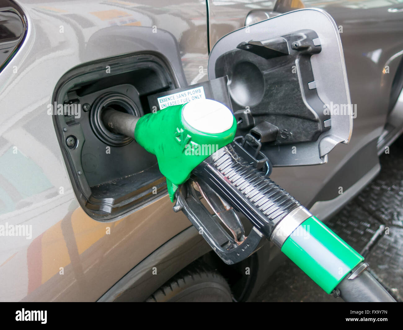 Close-up of unleaded gas pump nozzle refilling the car in petrol station in the Netherlands Stock Photo