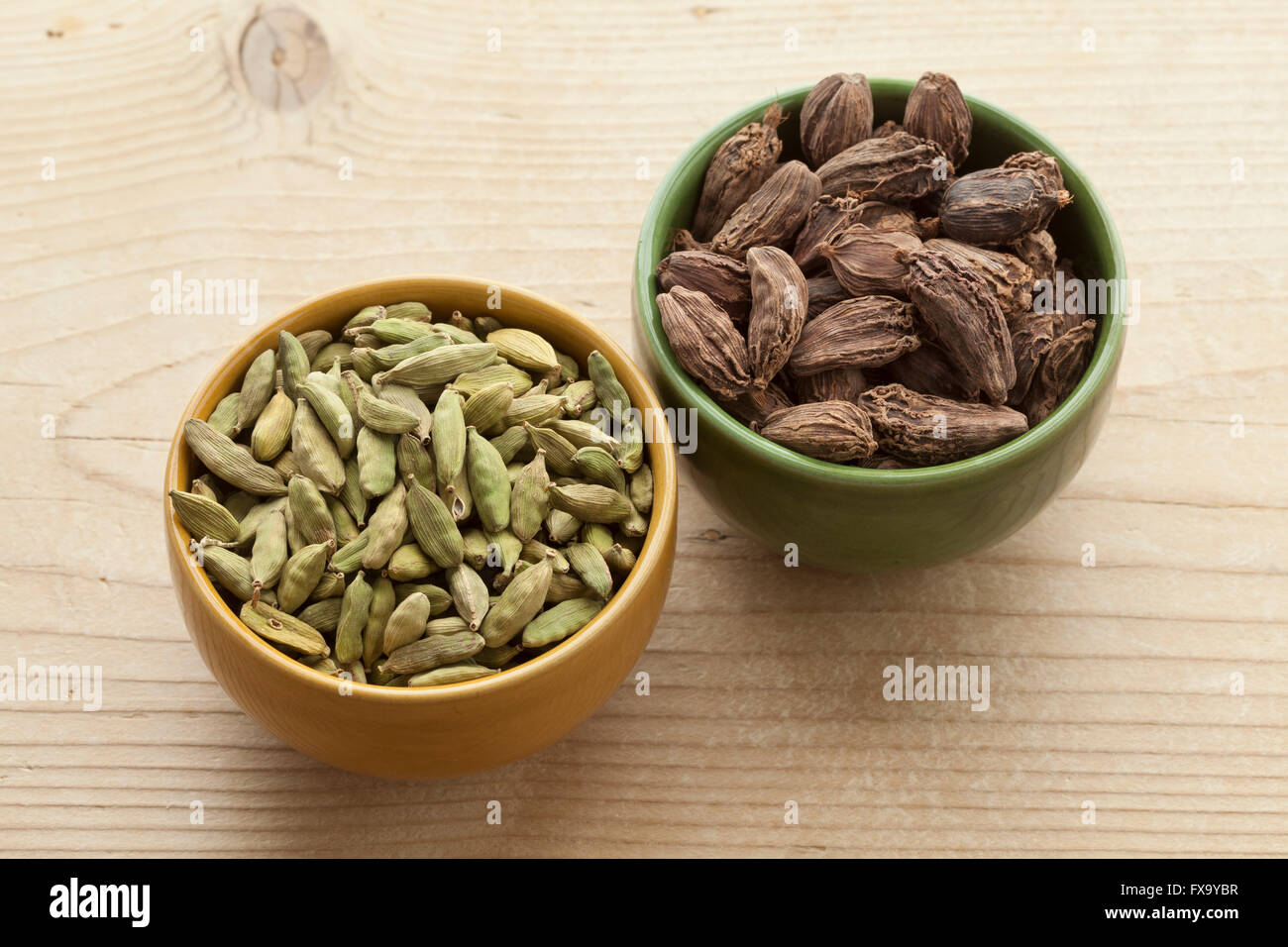 Bowls with green and large black Cardamom seeds Stock Photo