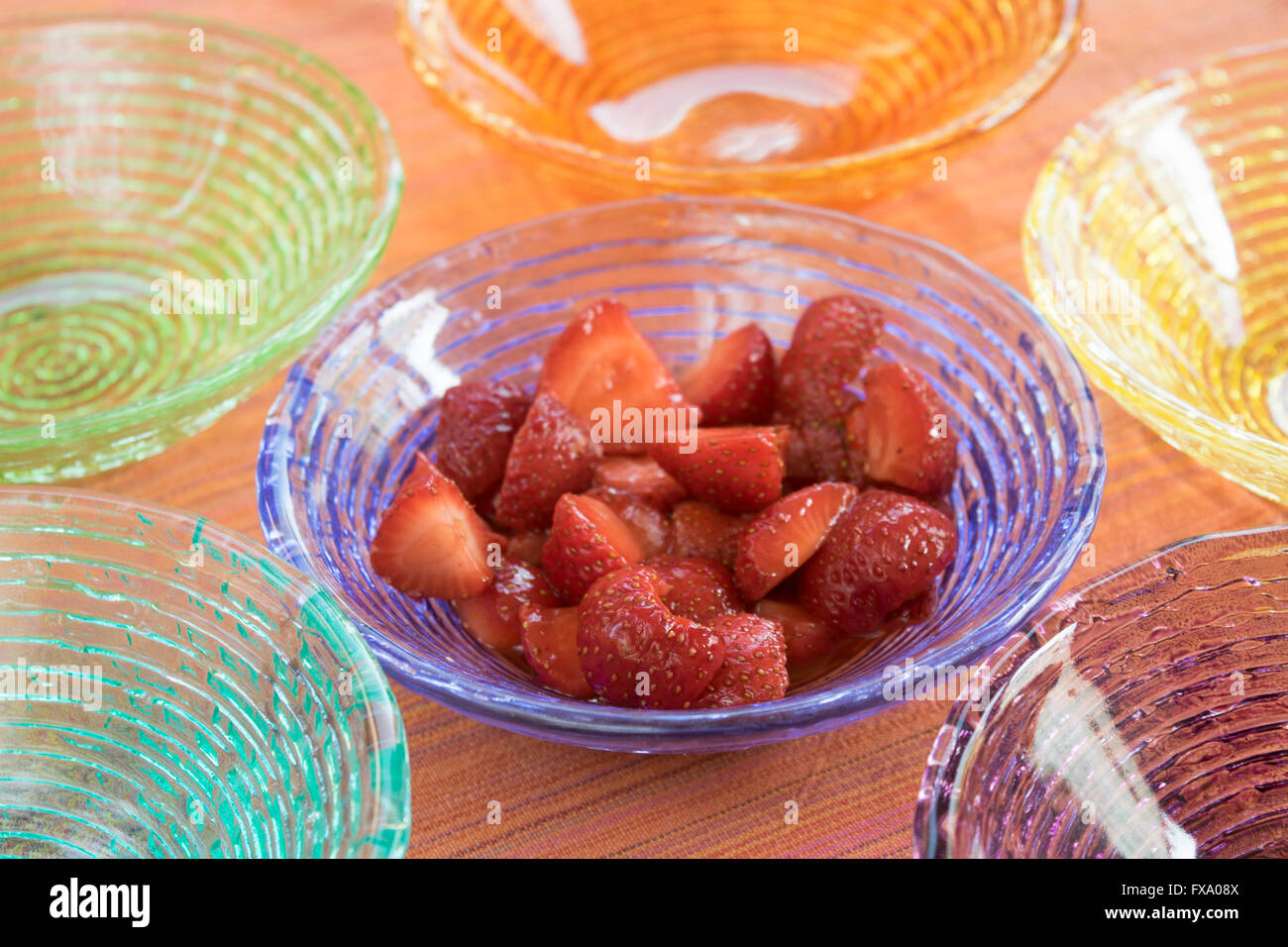 strawberry salad in a sequence of colored glass bowls Stock Photo