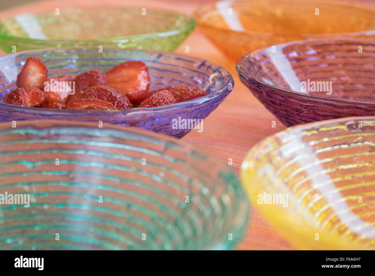 strawberry salad in a sequence of colored glass bowls Stock Photo
